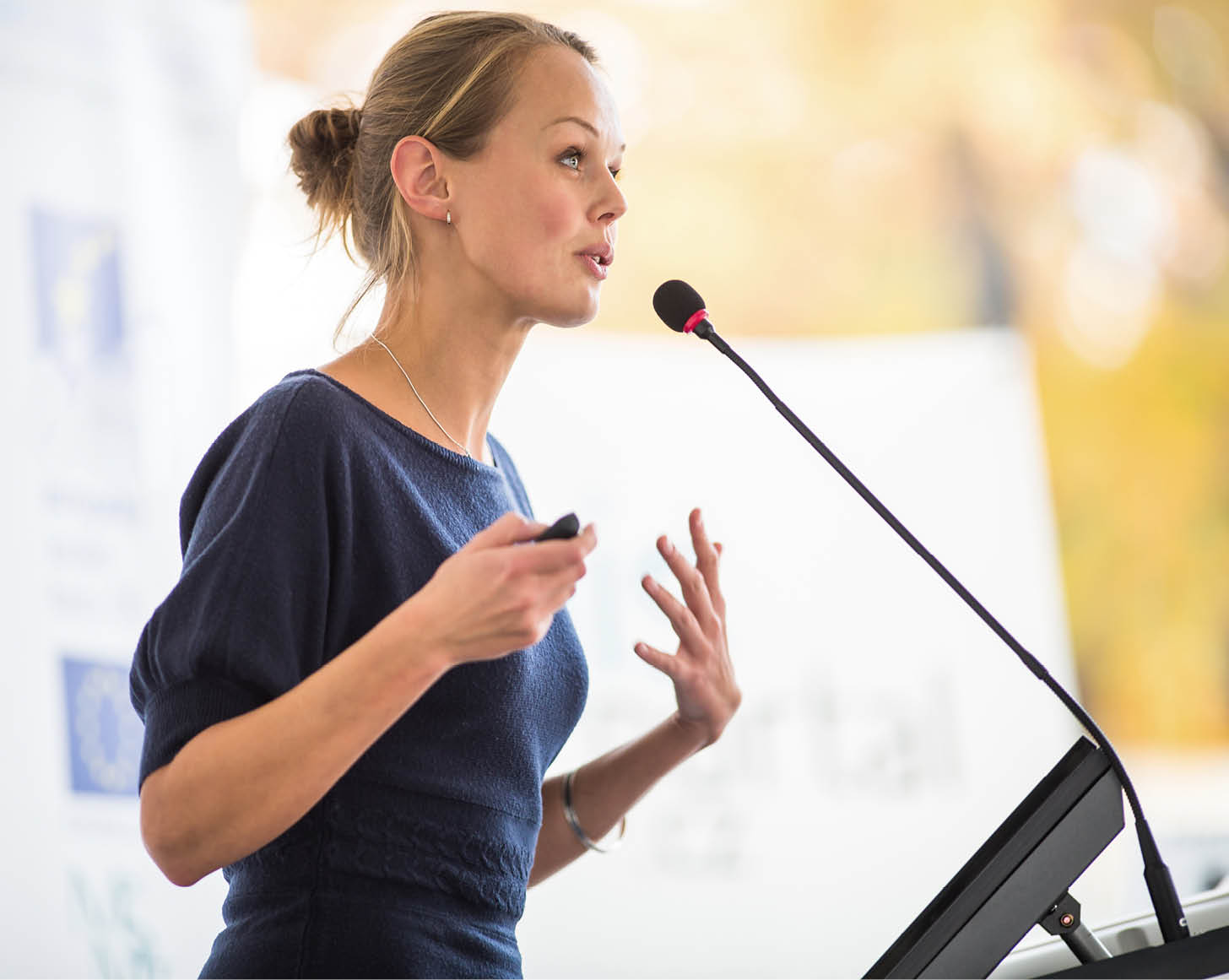 Pretty, young business woman giving a presentation in a conference meeting setting (shallow DOF; color toned image)